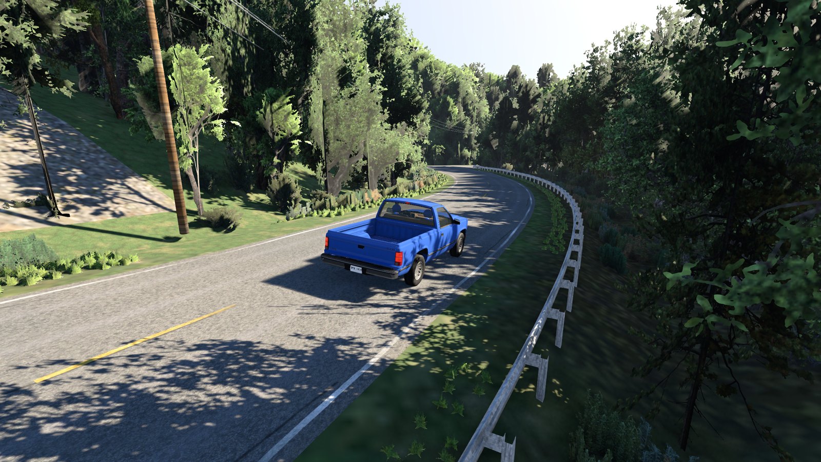 A pickup on a winding wooded road with a guardrail and power poles, in BeamNG.drive